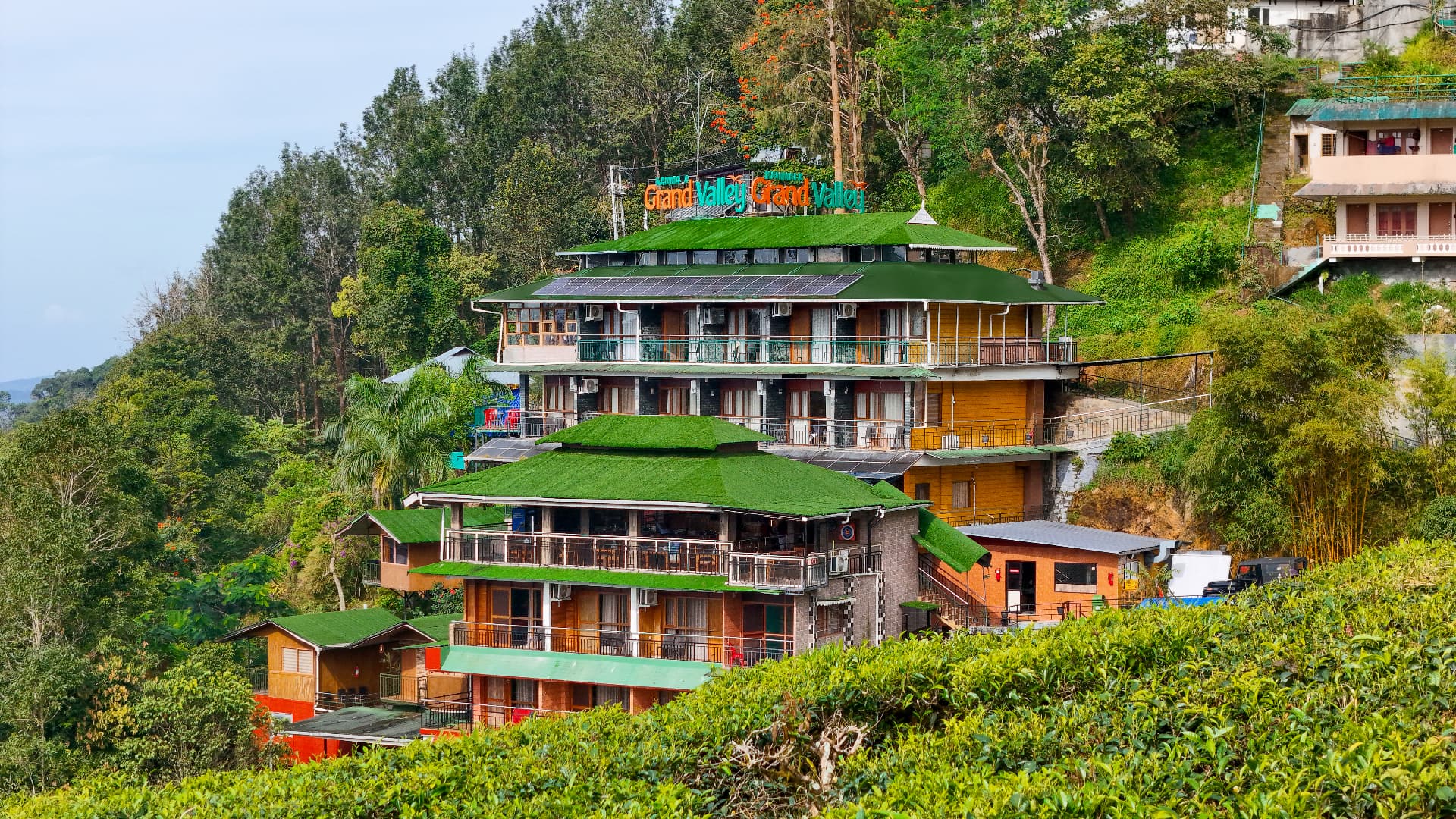 Full facade of Grand Valley Resort stepping down the tea-covered hillside in Munnar