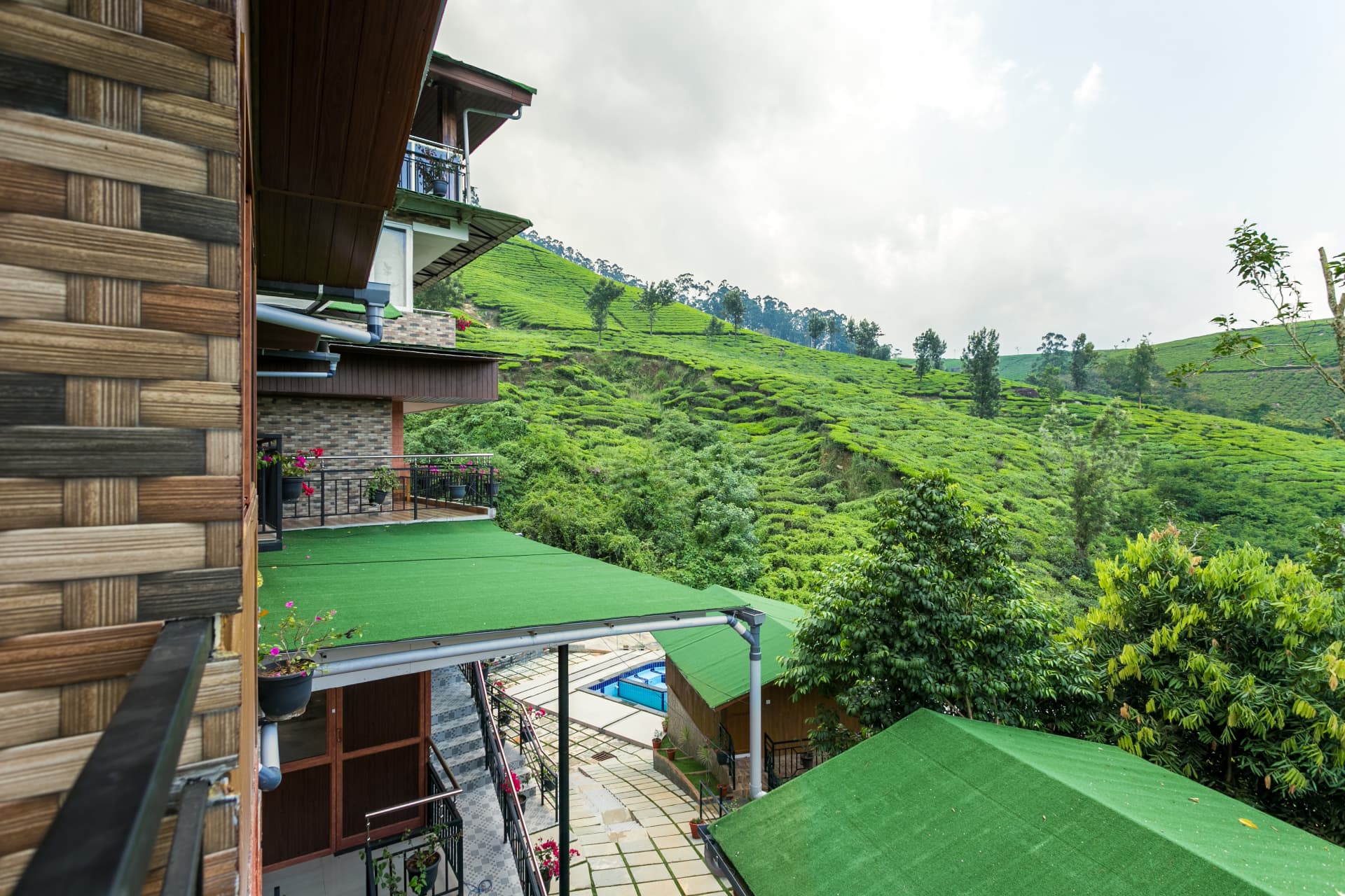 View from the Premium Valley View Hut balcony over the pool and the tea hills