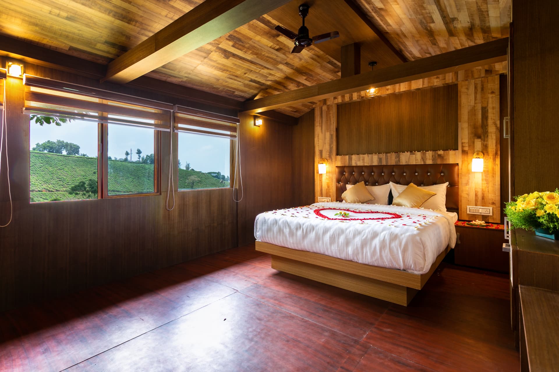 Family Suite Hut at Grand Valley Resort Munnar — master bedroom in teak with a picture window over the tea slope
