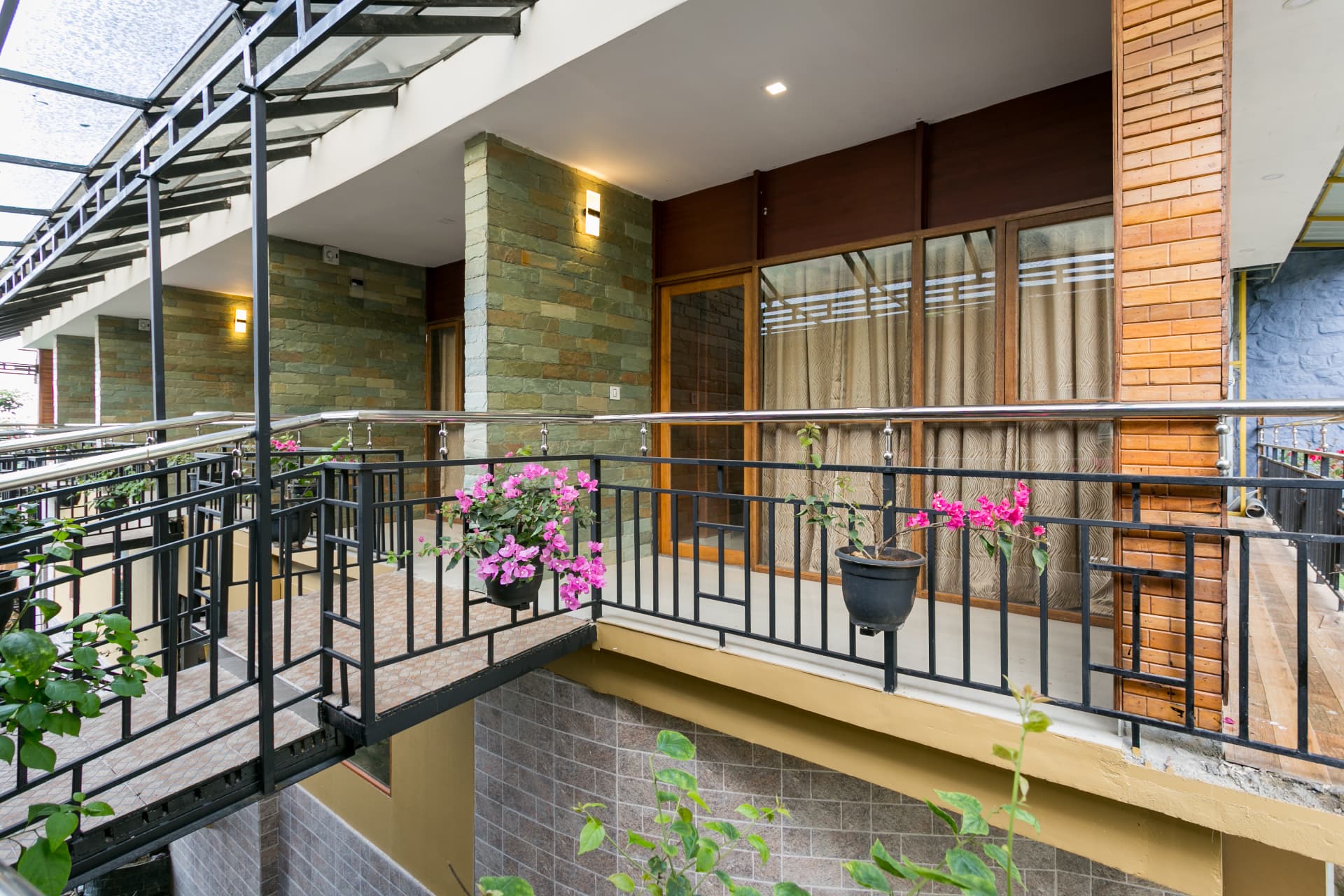 Deluxe Non Valley View Room at Grand Valley Resort Munnar — stone-clad entrance verandah with bougainvillea pots