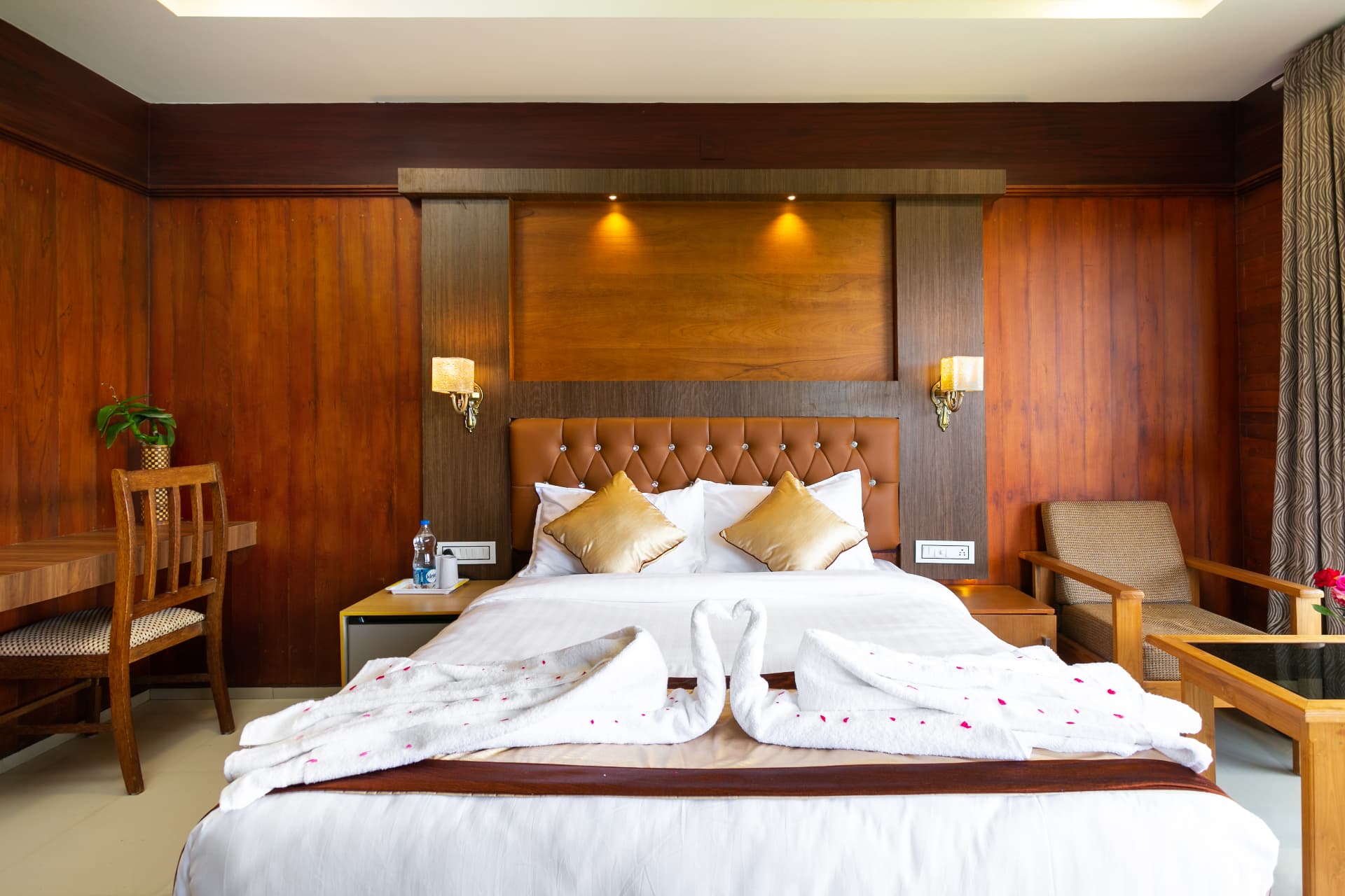 King bed of the Premium Valley View Room beneath the lit teak headboard