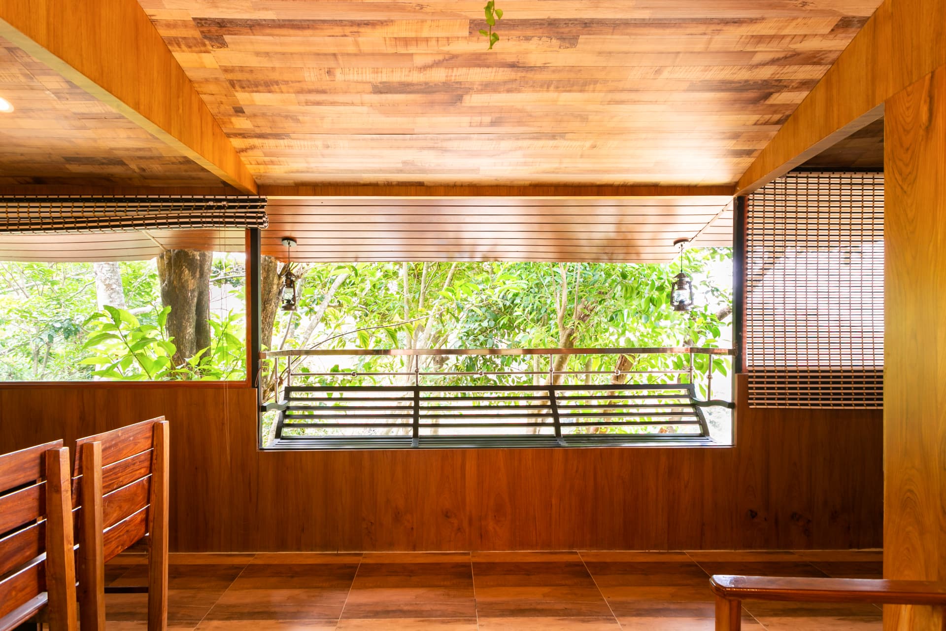 Private verandah of the Family Suite Hut with lanterns, opening into the trees