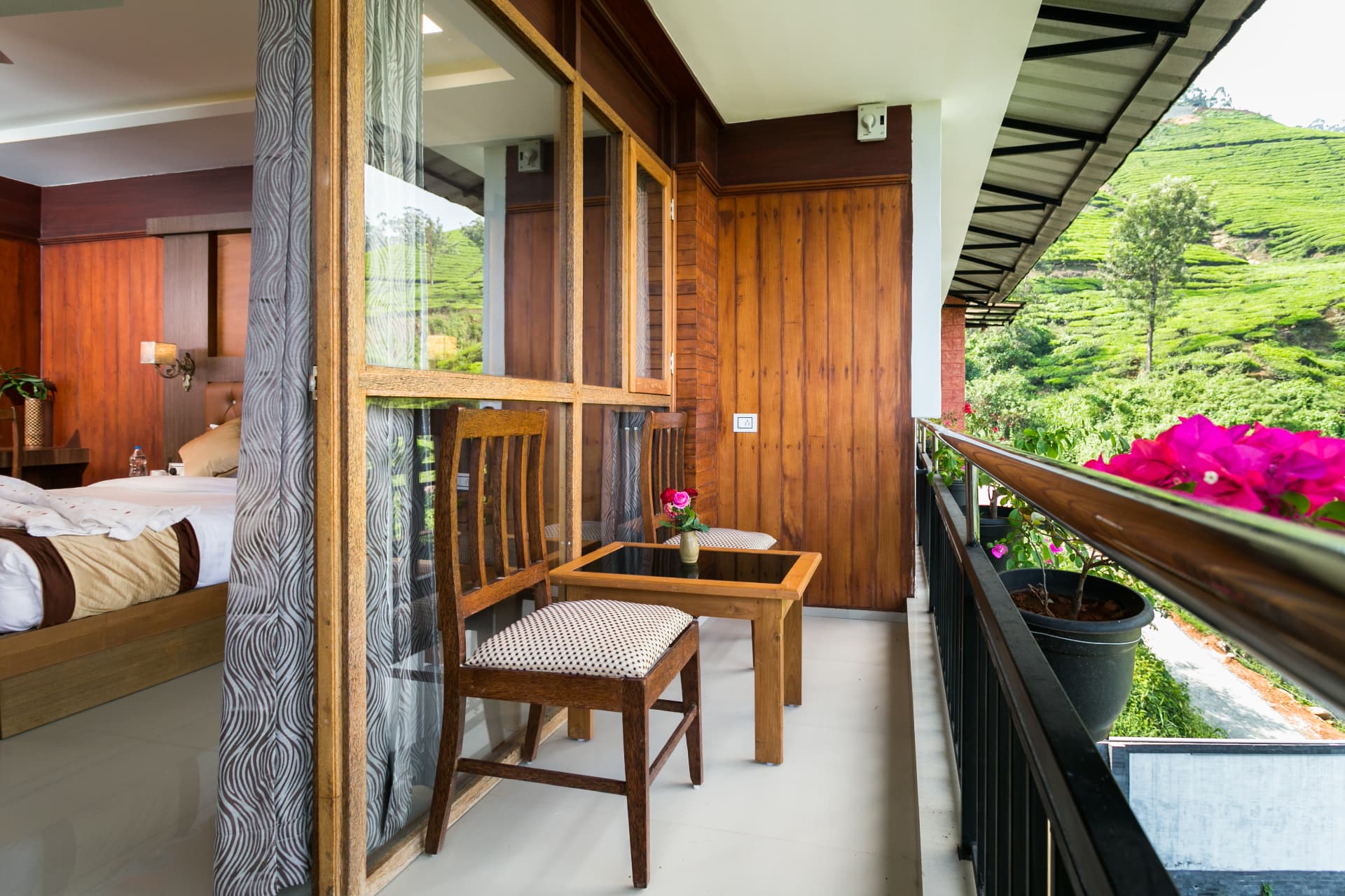 Private balcony of the Premium Valley View Room with chairs and table above the tea garden